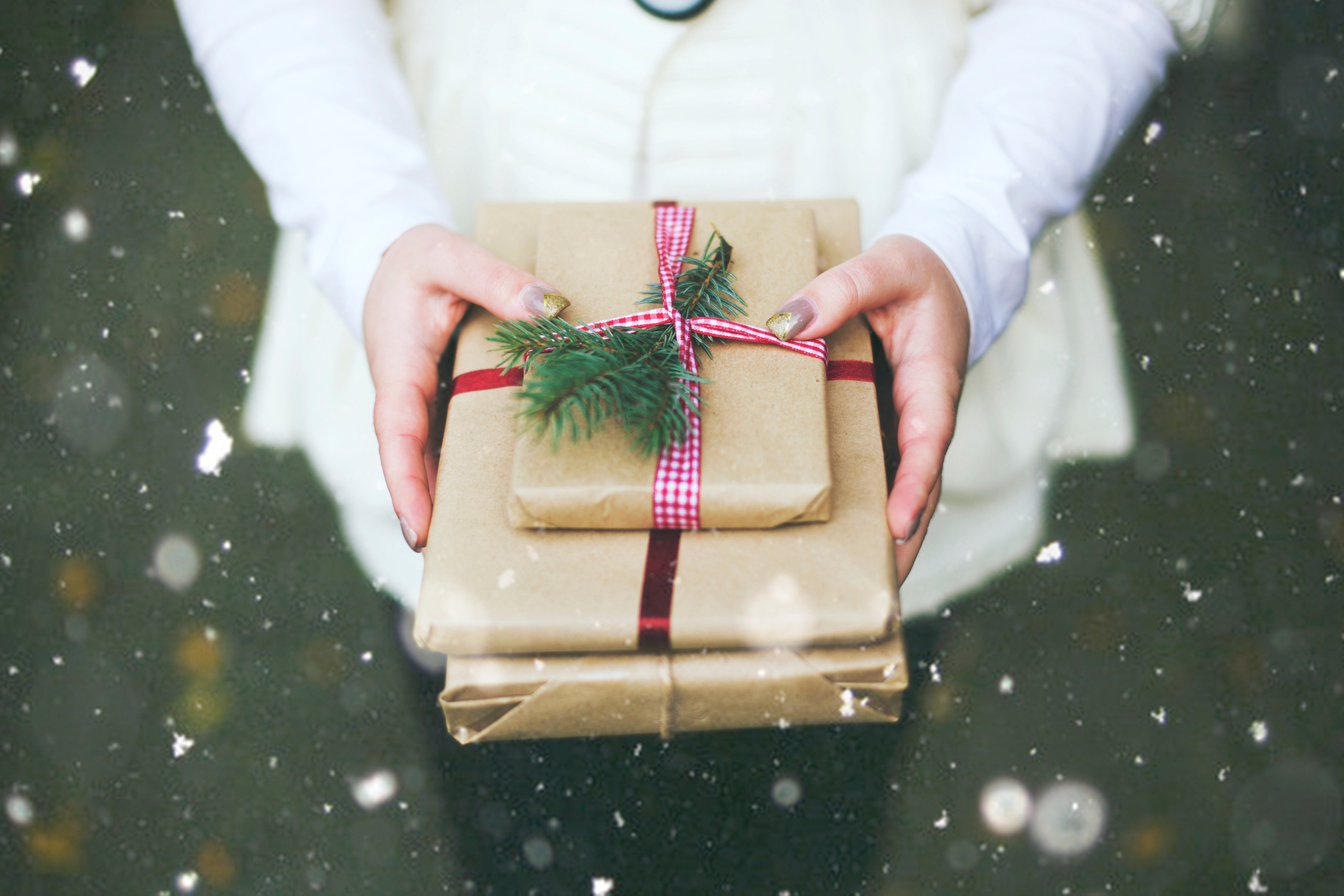 Hands holding wrapped presents.
