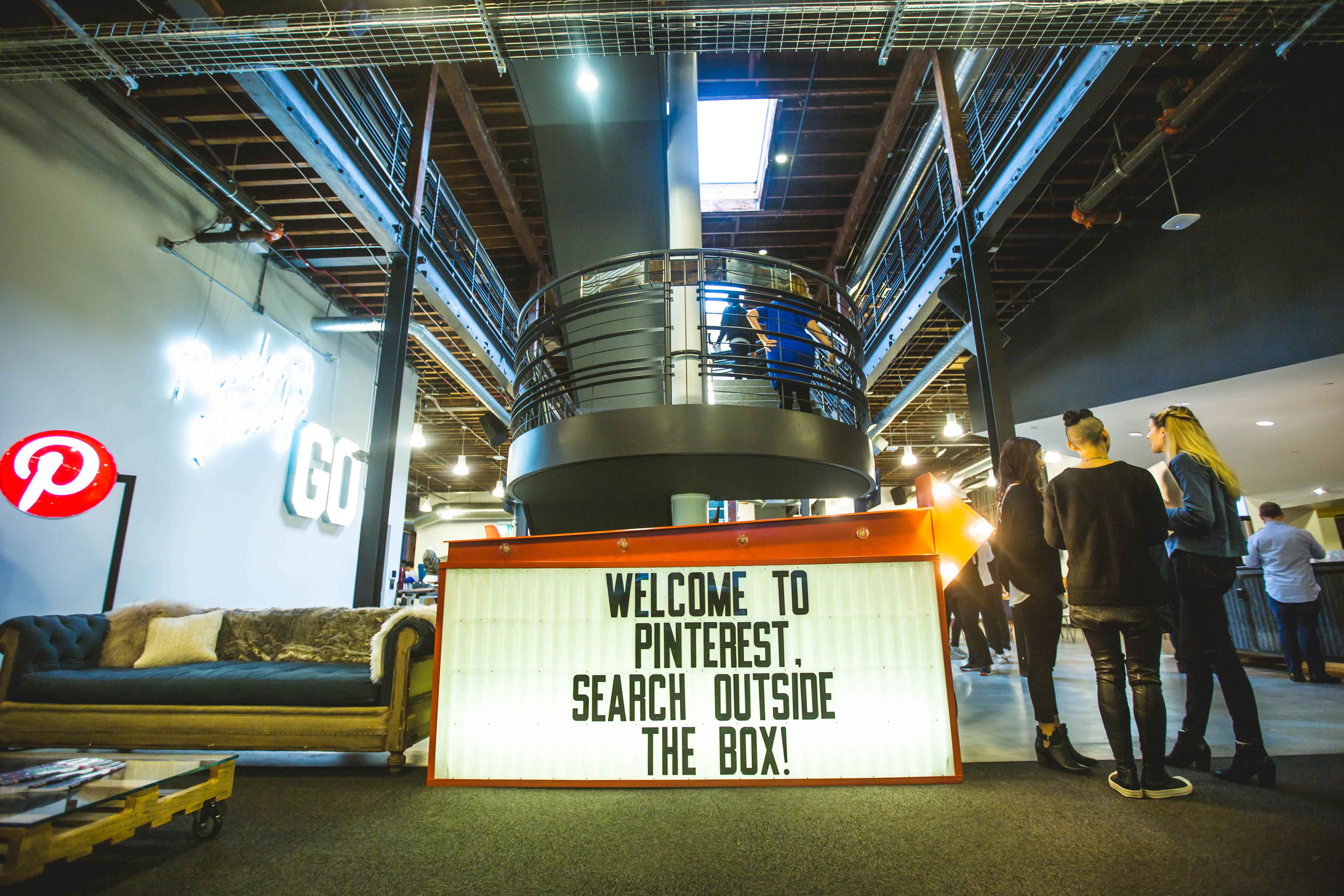 Inside Pinterest office people standing and a sign.