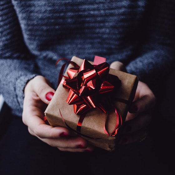 Picture of 2 hands holding a wrapped gift 