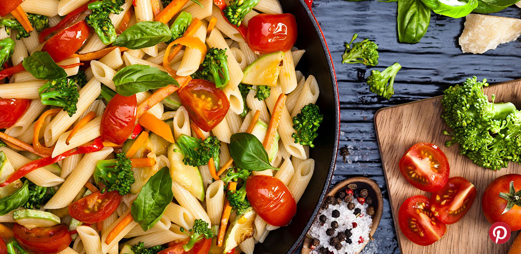 Pasta salad with broccoli , tomato and basil.