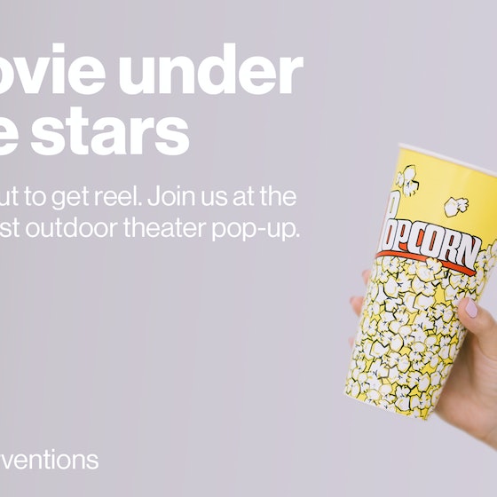 Hand holding popcorn cup.