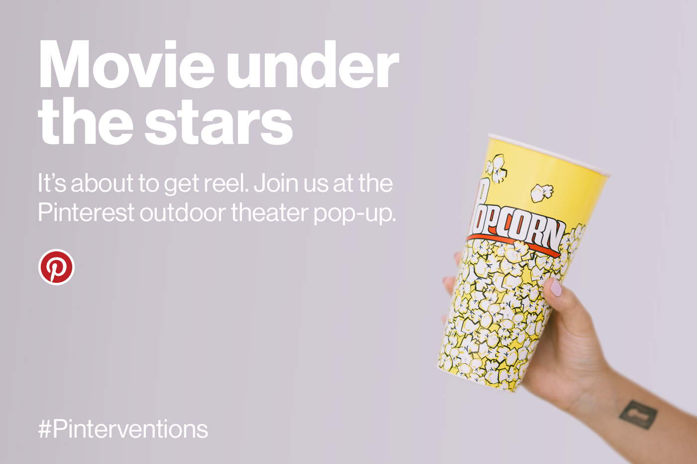 Hand holding popcorn cup.