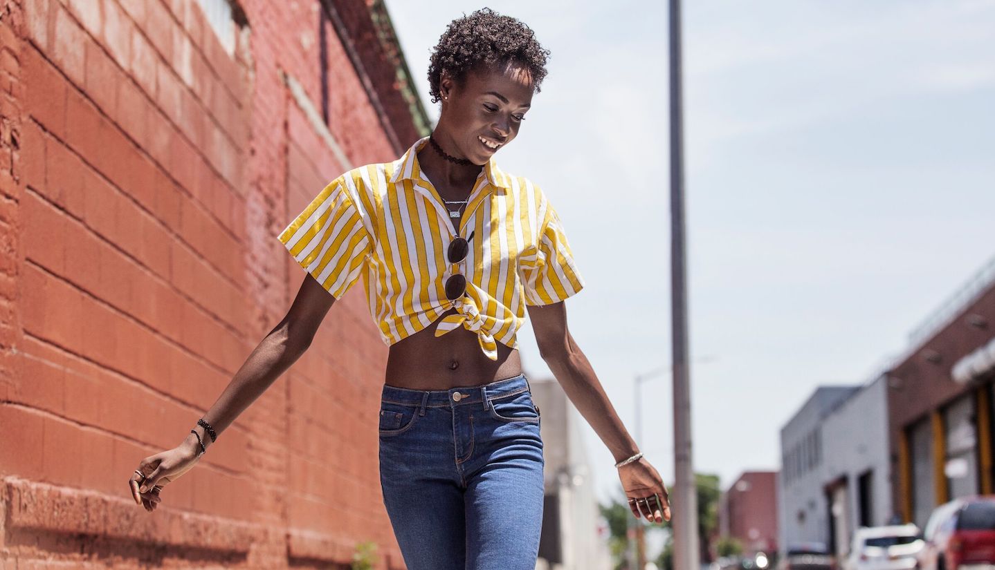 girl walking outside swinging arms smiling