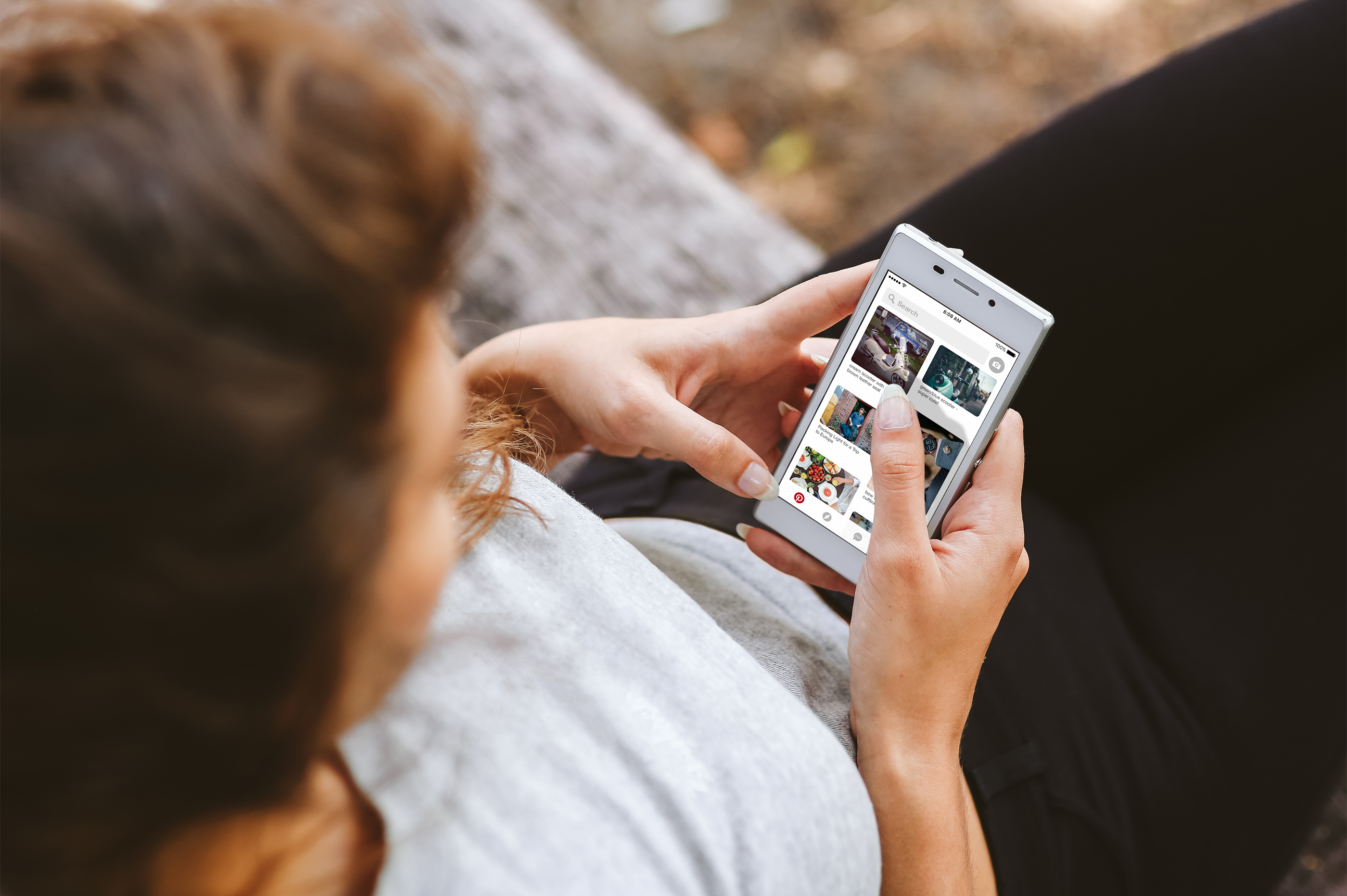 Woman on Pinterest app on phone.